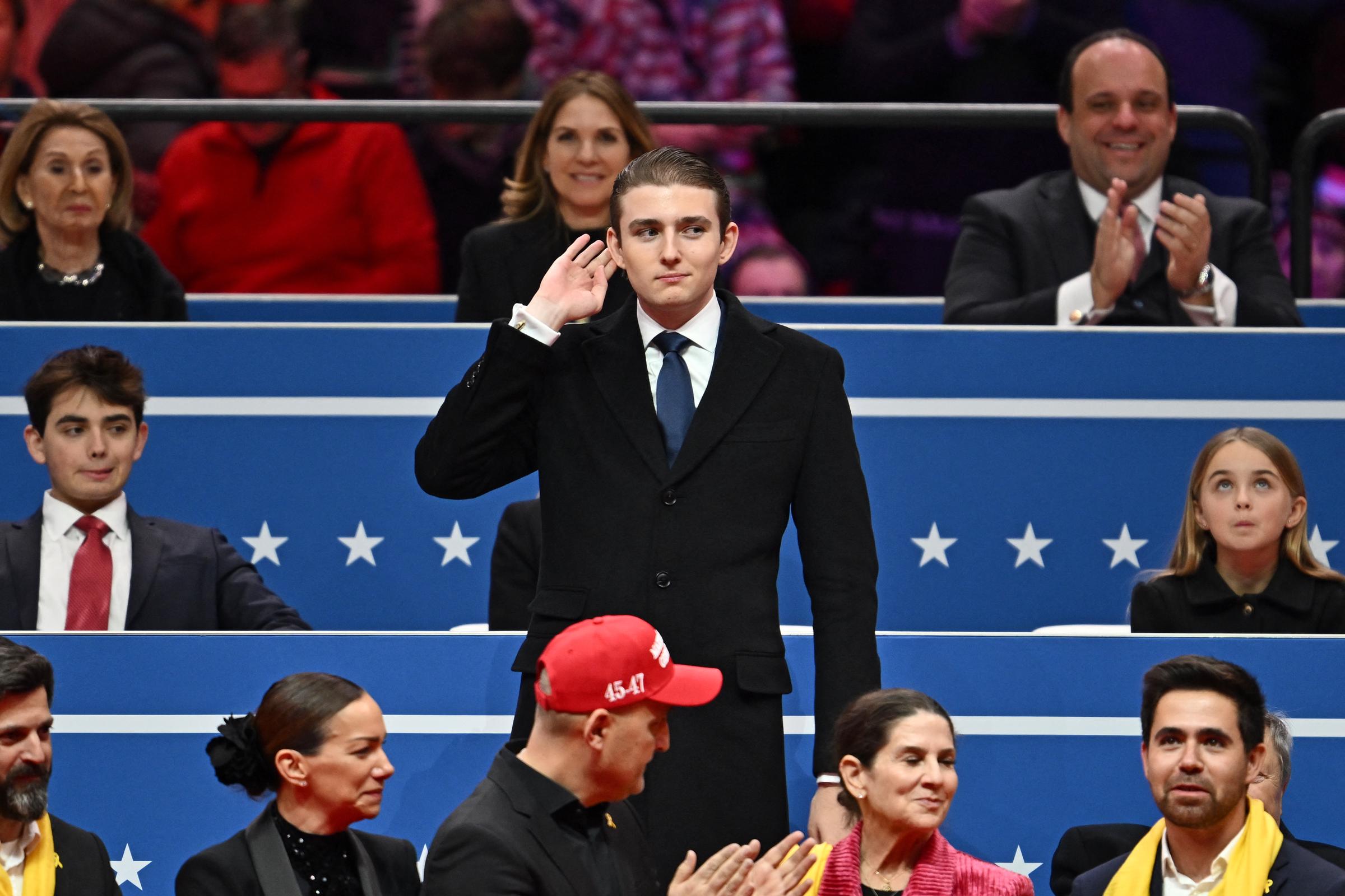 Despite appearing so rarely, Barron Trump showed his charisma nicely. In this photo, he gestured after being acknowledged by his father during the inaugural parade inside Capital One Arena on January 20, 2025, in Washington, DC. | Source: Getty Images