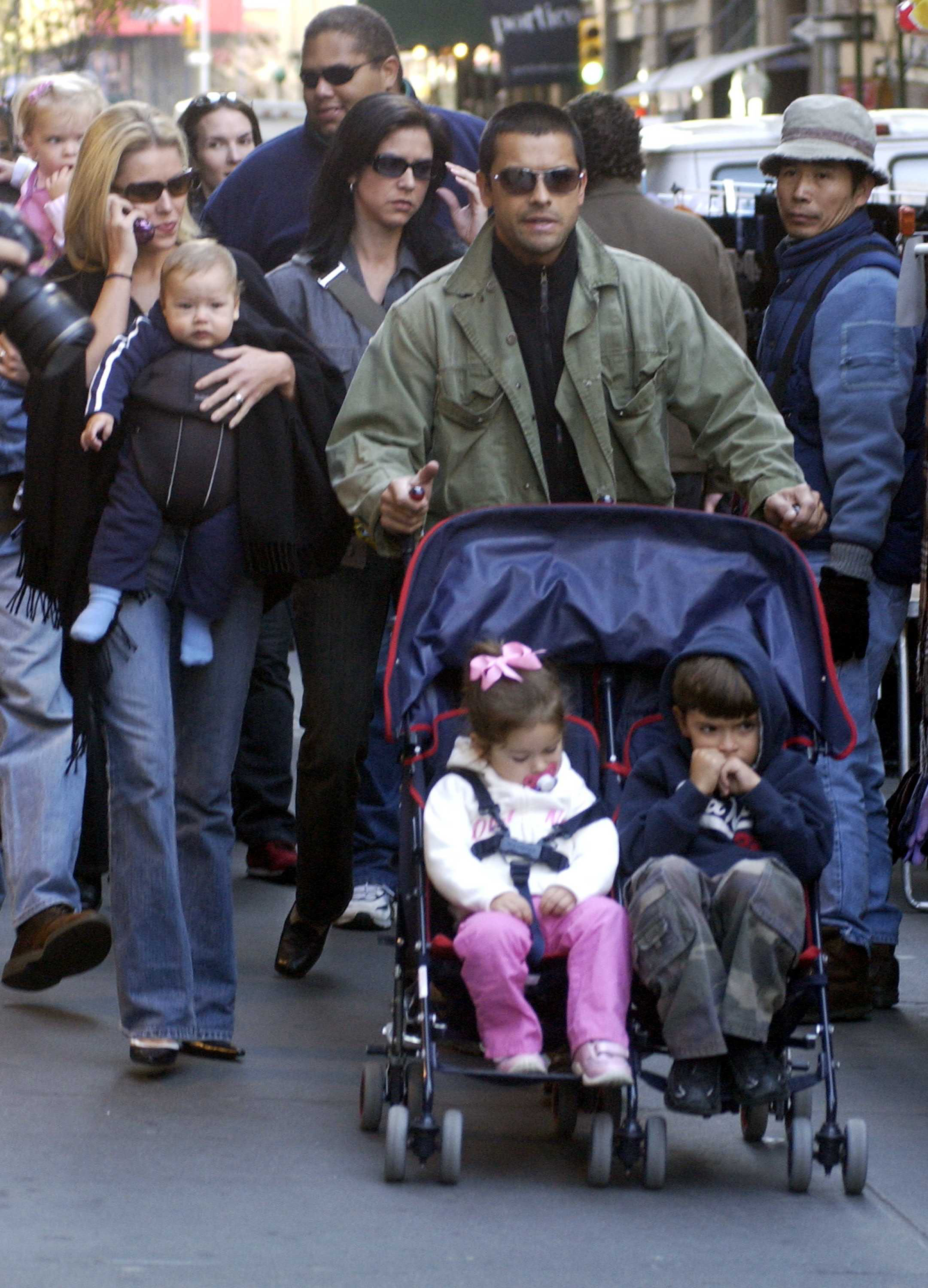 Kelly Ripa and Mark Consuelos walk through New York City with their three children in 2003. The photo captures the family during the early years that would later be documented in photos shared over time. | Source: Getty Images