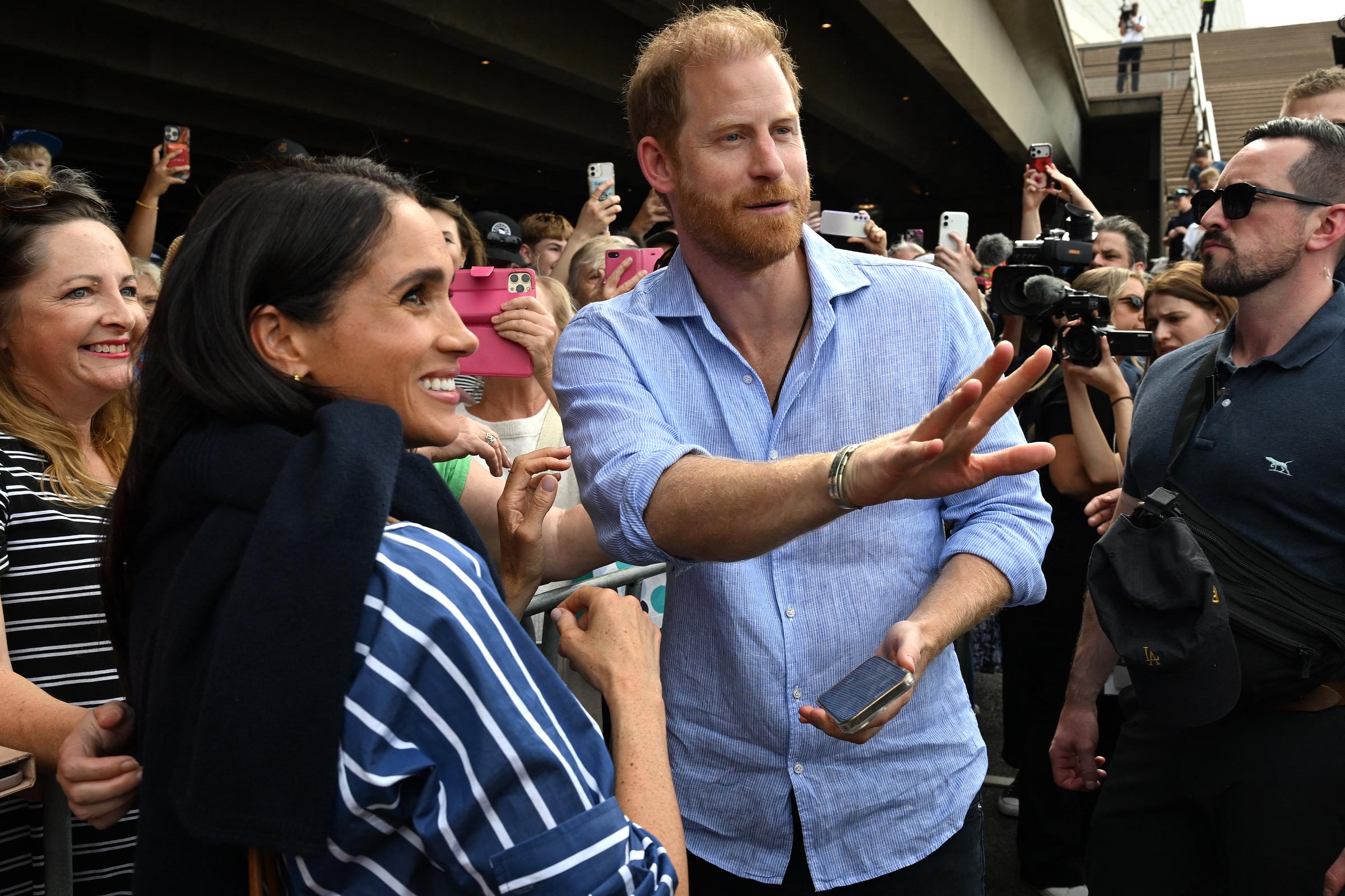 Książę Harry, książę Sussex, i jego żona Meghan, księżna Sussex, spotykają się z publicznością pod schodami kultowej australijskiej opery w Sydney 17 kwietnia 2026 r. | Źródło: Getty Images