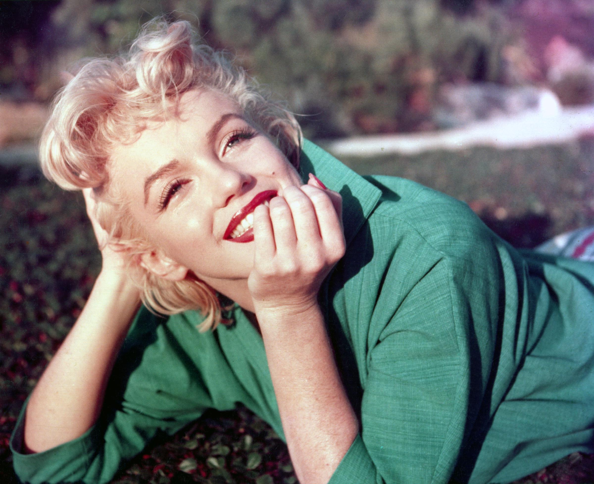Marilyn Monroe poses for a portrait laying on the grass in 1954 in Palm Springs, California. | Source: Getty Images