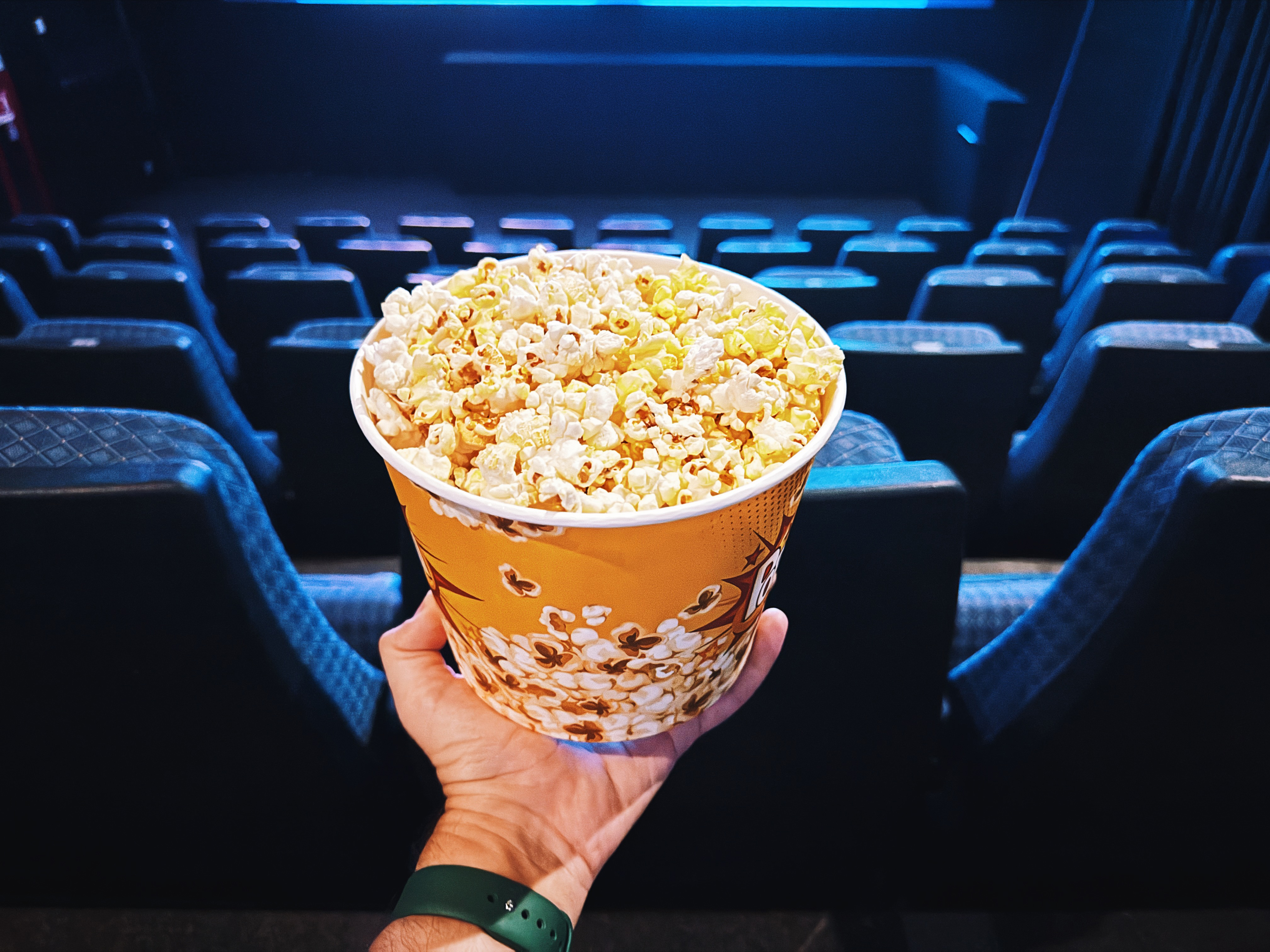 A close up of a hand holding a bucket of popcorn | Source: Getty Images