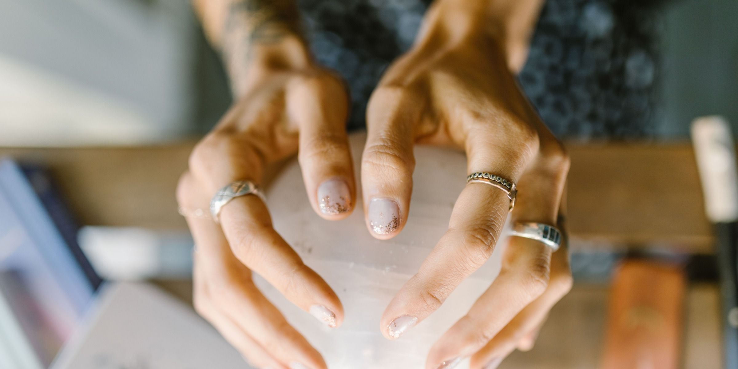 Hands in rings hold a crystal sphere | Source: Pexels
